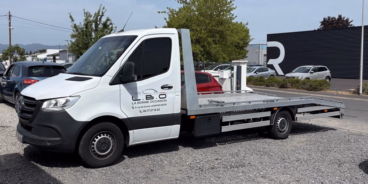 Camion plateau Mercedes Sprinter floqué L.B.O, garé sur le parc du garage à Lempdes