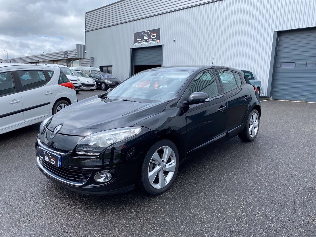 Renault Mégane noire photographiée devant le hangar du Garage LBO à Lempdes